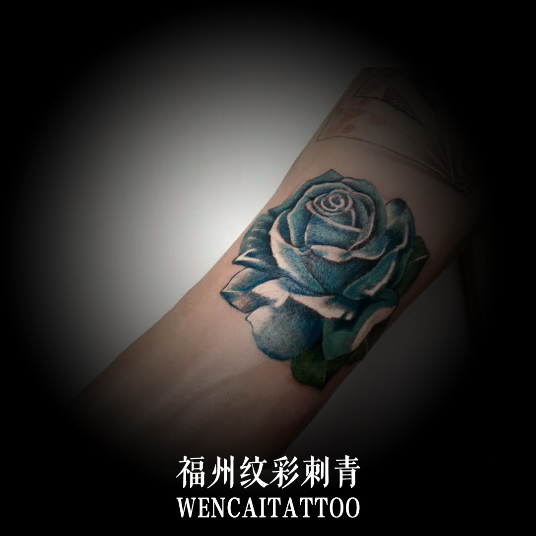 倪先生小臂上的精致蓝色玫瑰纹身图案
